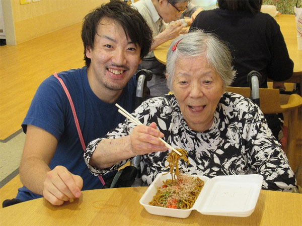 焼きそばを食べ喜ぶご利用者