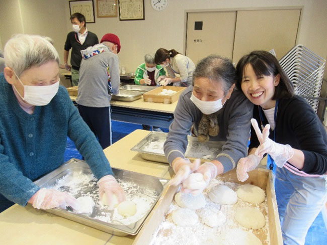 お餅を丸めるのに奮闘中