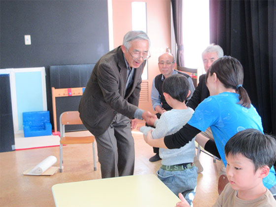 石津さんと握手する子どもたち